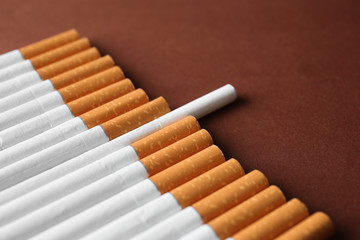 Many cigarettes on color background. Concept of uniqueness