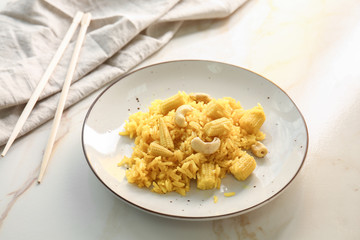Plate with tasty rice, corn and nuts on light table