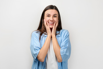 Portrait of beautiful surprised woman in casual clothes on light background