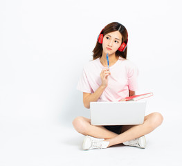 Happy student girl sitting on the floor using laptop