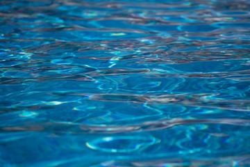 Blurred water texture in summer pool close up.