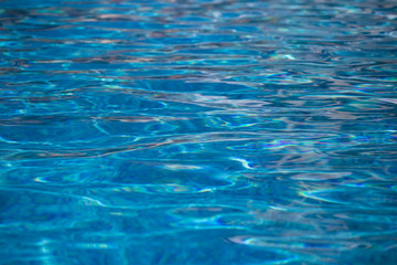 Blurred water texture in summer pool close up.