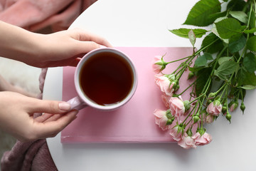 Woman drinking hot tea at home, closeup