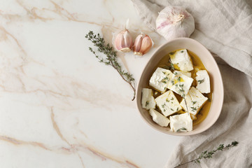 Plate with tasty feta cheese, thyme and olive oil on light background