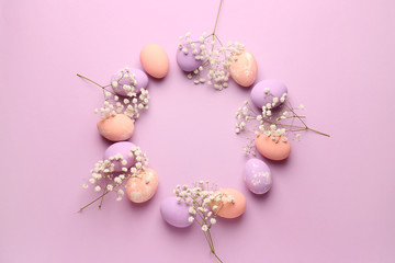 Frame made of Easter eggs on color background