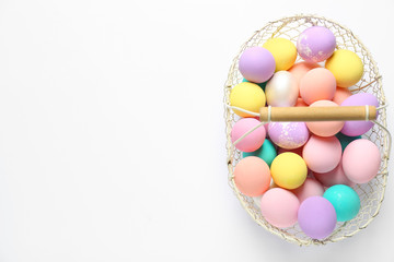 Fototapeta na wymiar Basket with colorful Easter eggs on white background