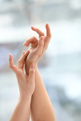 Hands of young woman applying cream at home