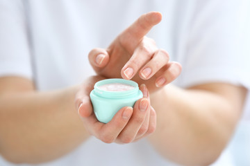 Young woman applying hand cream, closeup