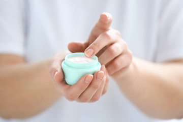 Young woman applying hand cream, closeup