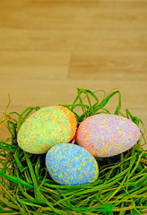 Obraz na płótnie Canvas colorful easter eggs with hay