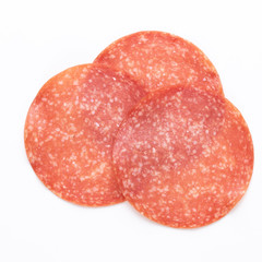 Salami slices on white background.