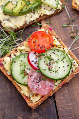 Sandwiches with cream cheese, vegetables and salami.