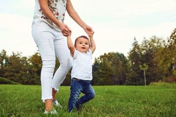 Fototapeta premium Mother with the child walks in the park in the summer. 