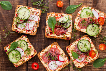 Sandwiches with cream cheese, vegetables and salami.