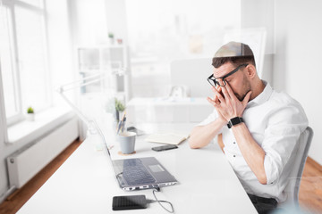 business, deadline and stress concept - tired businessman rubbing eyes at office