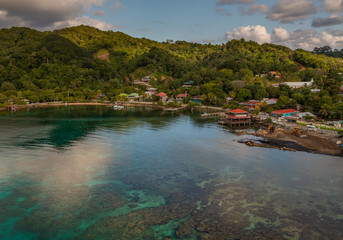 Fototapeta na wymiar Port of Roatan in the Hondures. Exposure of the Roatan port with its beautiful water, seen from a cruise ship, during morning with heavy clouds in the horizon. 