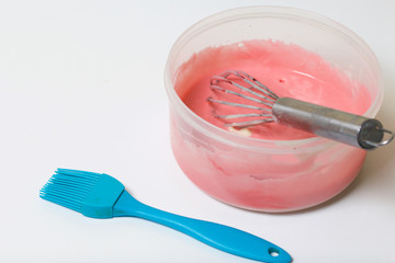 Cooking the pie with mascarpone cream. A whisk for mixing is in the container with the dough. Nearby is a culinary brush.
