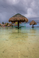 Palapa on the water by the beach. Typical Palapa in the beach of Roatan, Honduras. Exposure done during a cloudy day, with its beautiful and warm water.