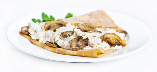 Thin delicious pancake with mushrooms and meat on white
