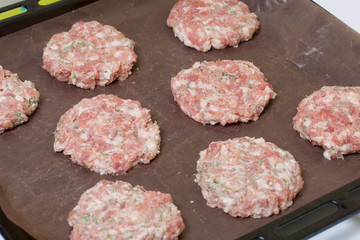Minced meat cutlets are on the baking sheet. Minced meat steaks with potatoes, eggs and cheese. Cooking steps and ingredients.