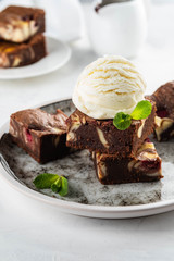 Fototapeta na wymiar Chocolate brownie with vanilla ice cream, rasberry and mint on a white background. Copy space.