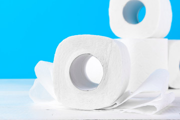Toilet paper rolls stacked against blue background