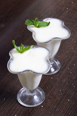 Creamers with sour cream jelly. Decorated with mint leaves.
