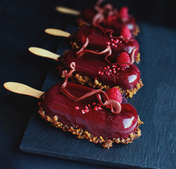Dark red berry gelato ice cream with raspberries on dark background
