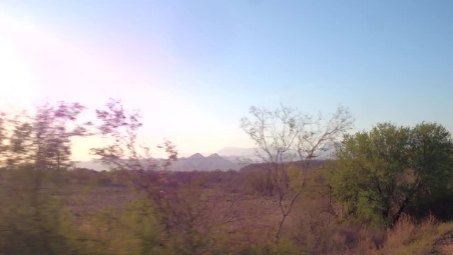 View from the window in a moving train through arid scenery