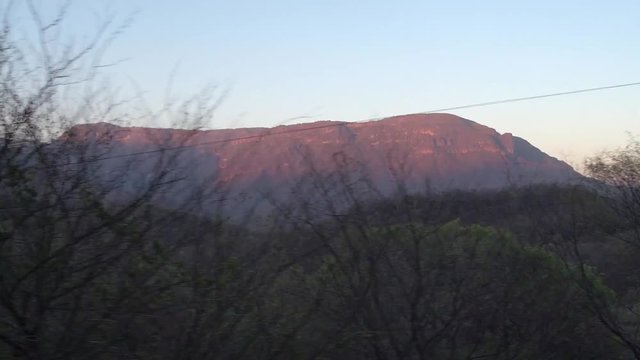 View from the window in the Cheep train through arid scenery at sunset