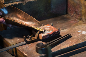 gold and silver granules in a  crucible for melting an alloy, jewelry tools in a goldsmith...
