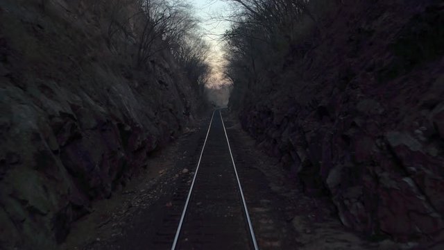 POV of a moving train passing through a narrow scary scenery