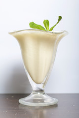 Ice-cream bowl with sour cream jelly. Decorated with mint leaves.