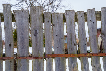 wooden fence of boards nailed to the crossbar