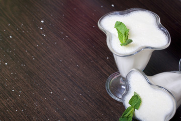 Creamers with sour cream jelly. Decorated with mint leaves.