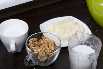 Cooking a cake of biscuit crumbs and milk jelly. On the surface of the table are the ingredients and cooking utensils.
