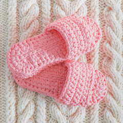 Womens pink Slippers on a white knitted wool carpet