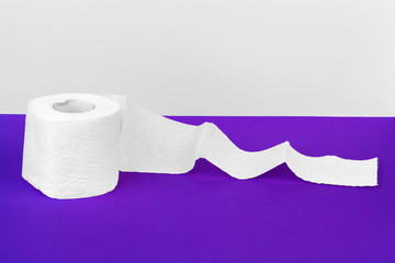 Toilet paper rolls isolated on white table with purple background