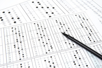 Man is filling OMR sheet handing with pen.