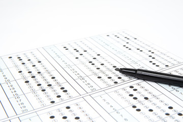 Man is filling OMR sheet handing with pen.