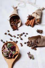Tea in wooden spoon, coffee cinnamon and anise in craft paper cornets. Rustic rope. Aromatherapy in the kitchen