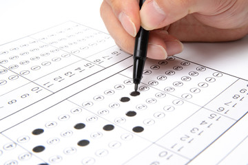 Man is filling OMR sheet handing with pen.