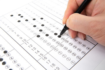 Man is filling OMR sheet handing with pen.