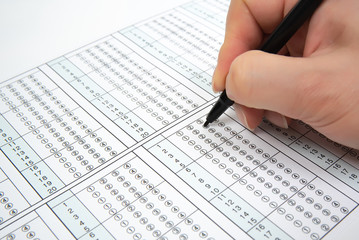 Obraz premium Man is filling OMR sheet handing with pen.