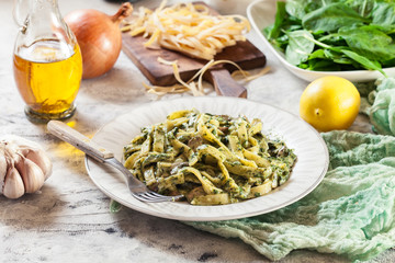 Tagliatelle pasta with spinach and mushrooms on a plate