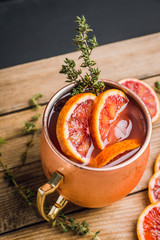 Red oranges cocktail in copper mug (variation of Moscow mule) on the wooden background. Selective focus. Shallow depth of field.