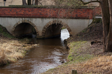 Fototapeta na wymiar Fluss fließt unter der Brücke