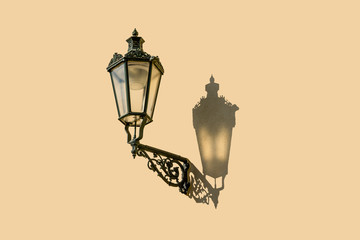 Street lamp with a shadow on a one-color wall.