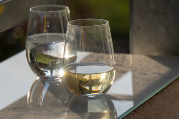 Wasserglas mit Weinglas auf Glasunterlage