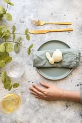 Happy Easter concept. Top view of woman hand and plate with  easter bunny, glass on wine. Festive bacground in Scandinavian style